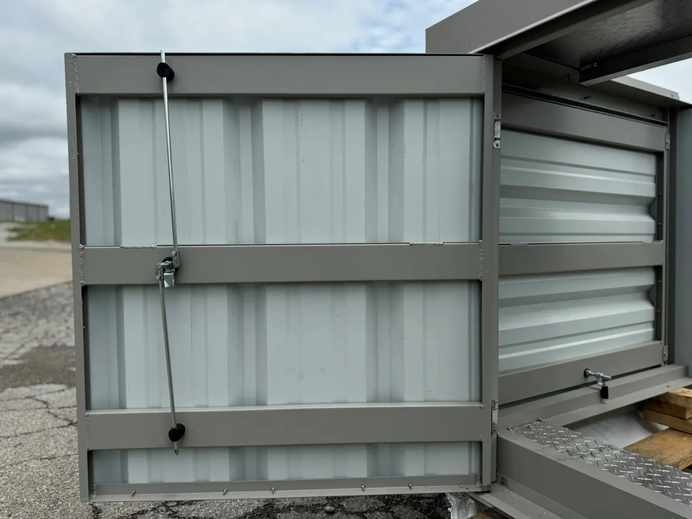 Interior of an RTU screen access door showing multi-point latch rods and corrugated panel