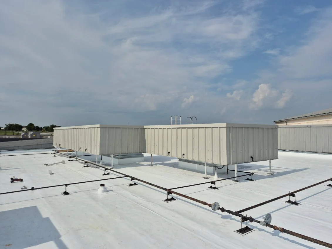 Two beige corrugated rooftop mechanical screens on a white membrane roof