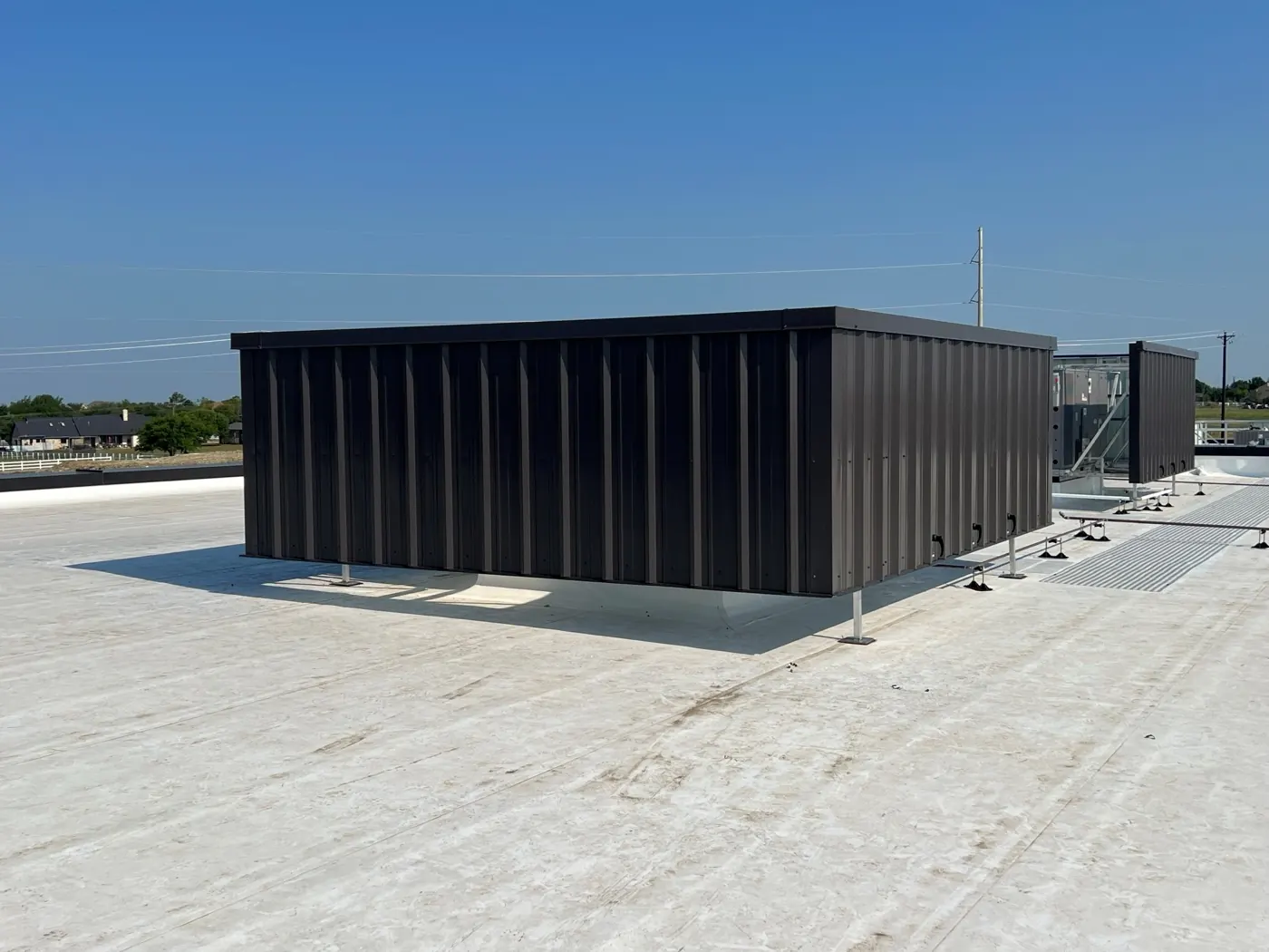 Dark bronze corrugated RTU screen wall on a flat commercial rooftop